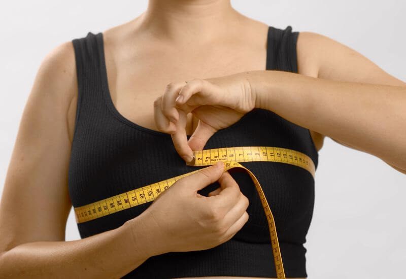 a woman measuring her breast