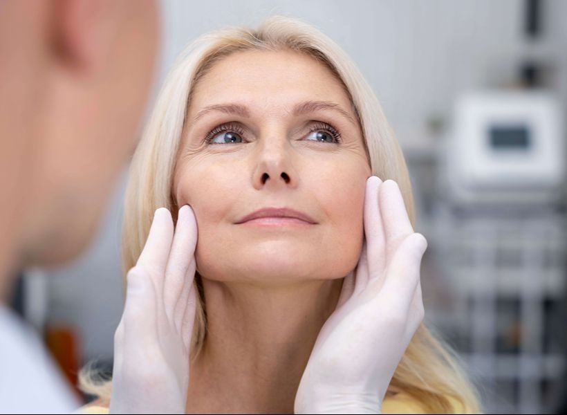 Middle-aged woman consulting with cosmetic surgeon about facial procedure