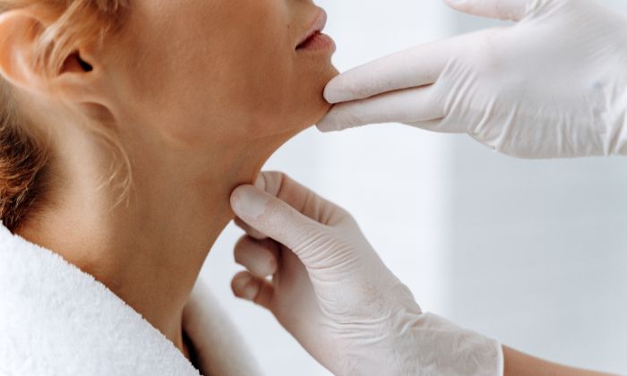 A cosmetic specialist examining a patient’s chin area before double chin removal treatment.