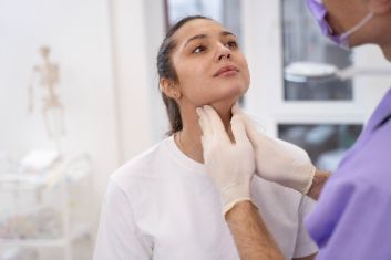 Surgeon examining a patient’s chin during consultation for double chin removal treatment.